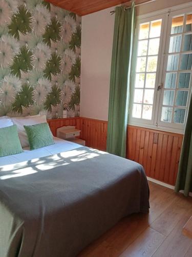 a bedroom with a bed and a wall with flowers at L'Auberge de Lugos in Lugos