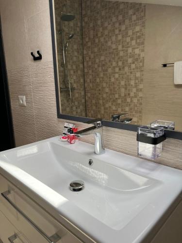 a white sink in a bathroom with a mirror at Noblesse Bacău in Bacău