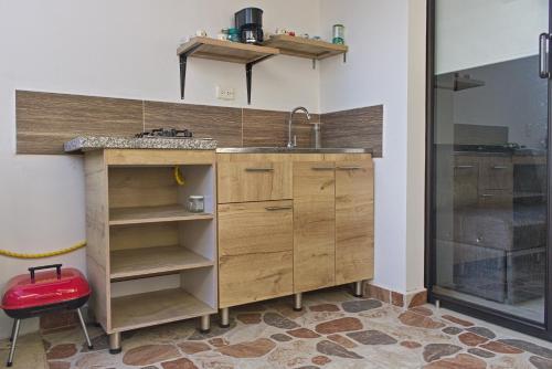 a kitchen with wooden cabinets and a sink at Villa Namaste - Cabaña Albores in Curití