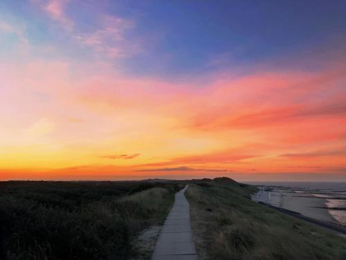 a road leading into the sunset on a hill at 't Soute Land in Zoutelande