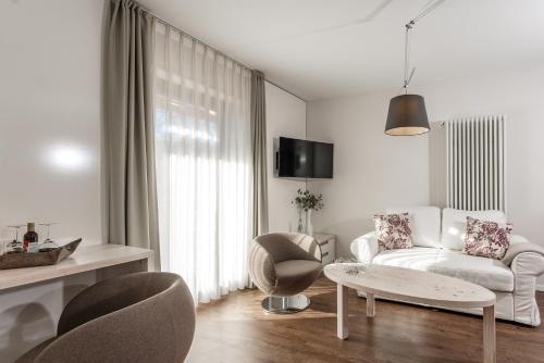 uma sala de estar branca com um sofá branco e cadeiras em Hotel Villa Lago Garni em Bad Wiessee