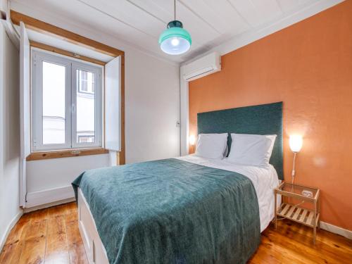 a bedroom with a large bed with a green blanket at Apartment in the heart of Lisbon in Lisbon