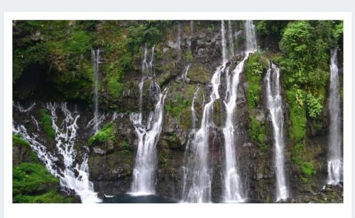 a group of waterfalls cascading down a rock wall at La Bohème in La Paix
