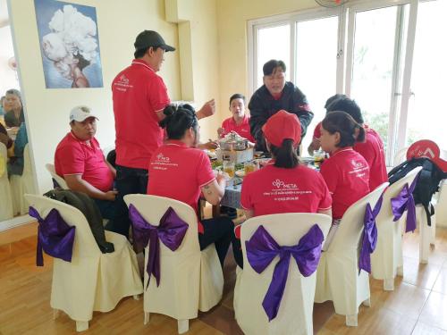 a group of people sitting around a table in a room at Mũi Dinh Hotel in Phan Rang