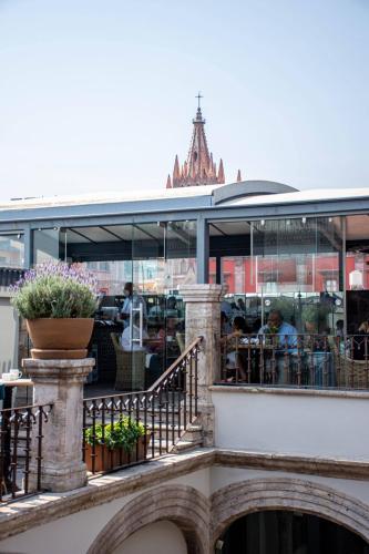 a balcony of a building with people sitting at tables at Casa 1810 Hotel Boutique in San Miguel de Allende