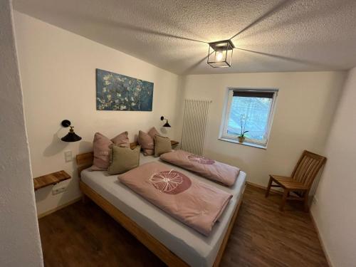 1 dormitorio con cama con sábanas rosas y ventana en Scheune 65, en Bad Frankenhausen
