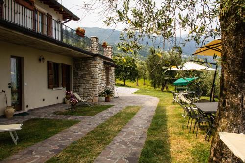 a patio of a house with a table and chairs at Agriturismo L'Uliveto in Gargnano