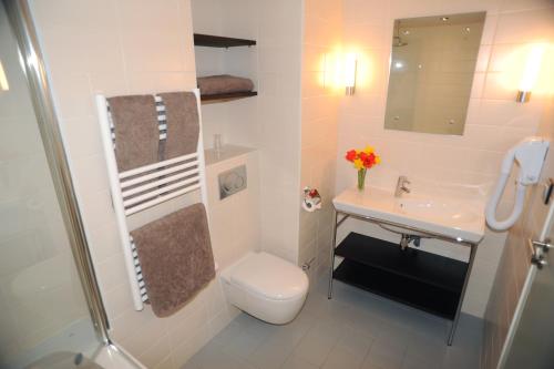 ein weißes Bad mit einem WC und einem Waschbecken in der Unterkunft Hotel Les Lanchers in Chamonix-Mont-Blanc