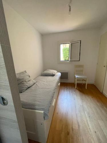 une petite chambre avec un lit et une fenêtre dans l'établissement Sanary charmant appartement bord de mer, à Sanary-sur-Mer