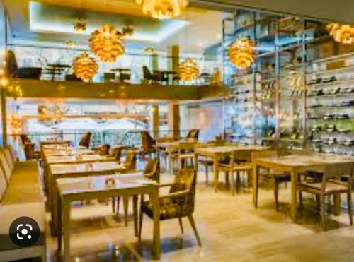 a restaurant with wooden tables and chairs and chandeliers at Taj Hotel Cape Town - Taj Residence suites in Cape Town