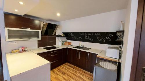 a kitchen with brown cabinets and a white counter top at Apartmán Tajov pre 5-6 osôb, privatne parkovanie a terasa in Tajov