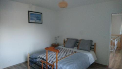 - une chambre avec un lit et une photo sur le mur dans l'établissement Terre brulée, à Blainville-sur-Mer