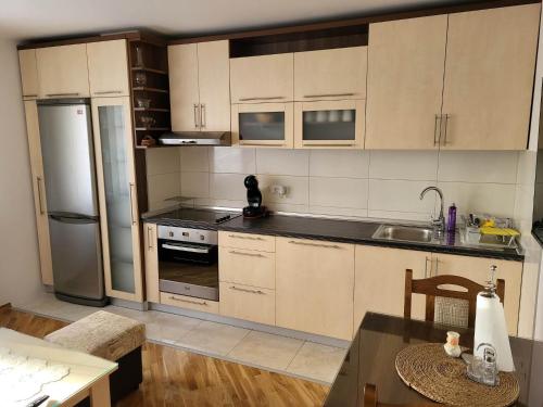 a kitchen with white cabinets and a stainless steel refrigerator at OPTIMUM 2 - One bedroom apartment in Zenica