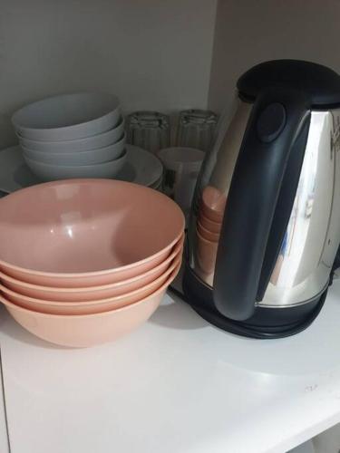 a counter with bowls and plates and a tea kettle at FlexiHome Studio Newly Renovate - 1 Queen 2 Single in Petaling Jaya