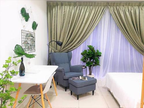 a living room with a chair and a bed and a window at FlexiHome Studio Newly Renovate - 1 Queen 2 Single in Petaling Jaya
