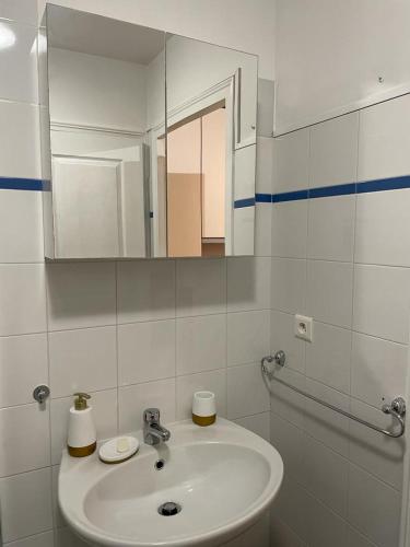 une salle de bain blanche avec un lavabo et un miroir dans l'établissement Studio Centre Ville, à Nice