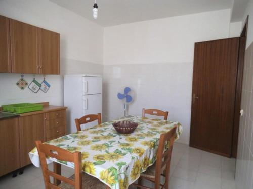 una cocina con mesa y sillas y una cocina con mesa y mesa. en Casa Derna 25dx, en Castellammare del Golfo