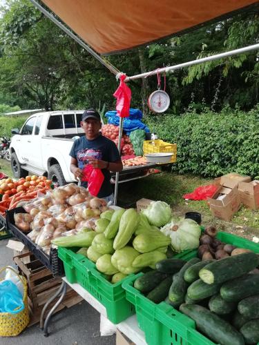 a man standing in front of a market with vegetables at Villa Cococaribic Isla Margarita Venezuela in Paraguachi