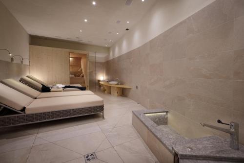 a bathroom with a bed and a tub in a room at Chalet Winklwiese in Valdaora