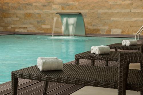 a swimming pool with two chairs and a fountain at Hotel Dom Goncalo & Spa in Fátima