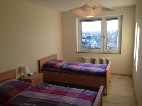 1 Schlafzimmer mit 2 Betten und einem Fenster in der Unterkunft Apartment Ginsterweg in Hannover