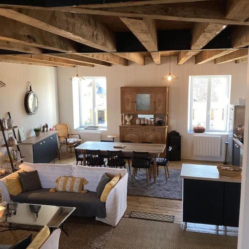 un salon avec un canapé et une salle à manger dans l'établissement Le Gite de la Fontaine (3*), à Chiddes