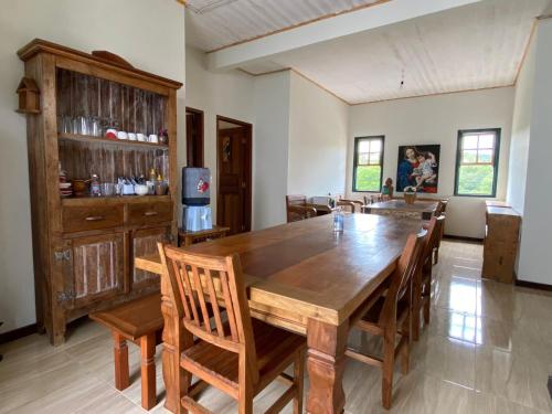 ein großes Esszimmer mit einem Holztisch und Stühlen in der Unterkunft Pousada Artes Evano in Bichinho