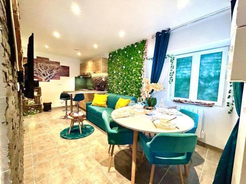 - un salon avec une table et un canapé vert dans l'établissement La forêt enchantée, centre ville, à Pont-sur-Yonne