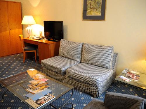 a living room with a couch and a desk at Grand Hotel Ukraine in Dnipro