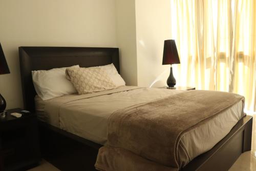 a bedroom with a bed with a lamp and a window at Alquiler Apto Ibiza Playa Corona- Reserva mínimo 2 noches in Copecito