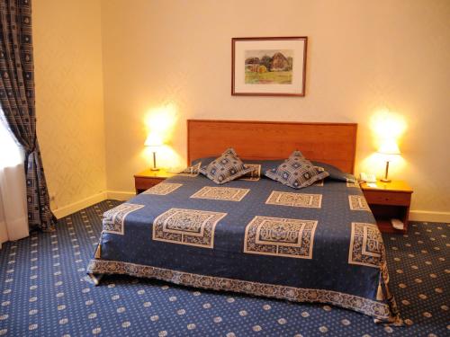 a hotel room with a bed with two lamps at Grand Hotel Ukraine in Dnipro