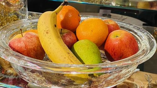 a bowl of fruit with bananas apples oranges and pears at Boutique Hotel Belle Epoque in Bern
