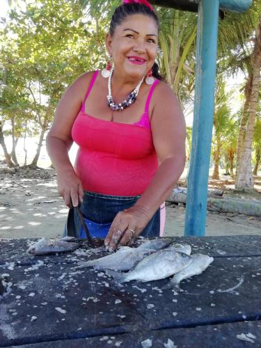 a woman is preparing fish on a grill at Villa Cococaribic Isla Margarita Venezuela in Paraguachi