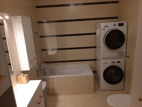 a bathroom with a washing machine and a washer at Villa na pokladzie in Władysławowo