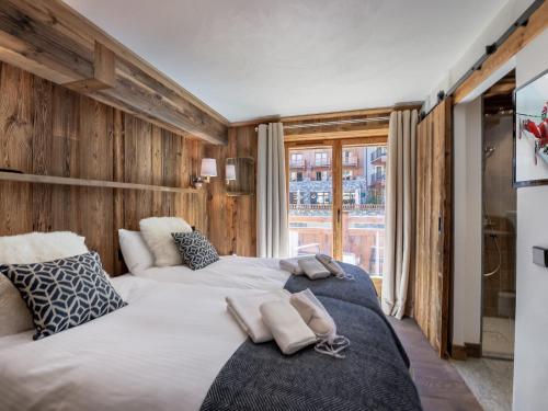 deux lits dans une chambre aux murs en bois dans l'établissement Appartement Ski-in/Ski-out, 3 Chambres, Cheminée, Parking, Val-d'Isère - FR-1-567-74, à Val dʼIsère