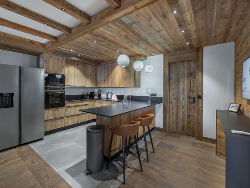 - une cuisine avec des plafonds en bois et un comptoir avec des tabourets dans l'établissement Appartement élégant avec jacuzzi à Val-d'Isère - 4 chambres en suite, proche piste de Bellevarde - FR-1-567-87, à Val dʼIsère