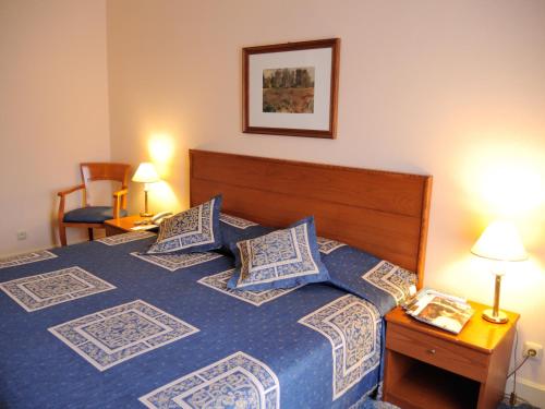 a bedroom with a blue bed with pillows at Grand Hotel Ukraine in Dnipro