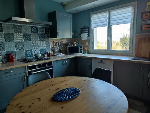 une cuisine avec une table en bois au milieu dans l'établissement chambre chez l'habitant aux Basses Besnardières, à Pontvallain