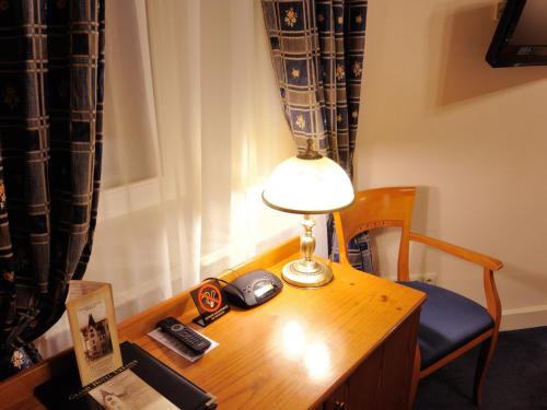 a desk with a lamp and a clock on it at Grand Hotel Ukraine in Dnipro