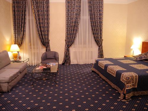 a hotel room with a bed and a couch at Grand Hotel Ukraine in Dnipro