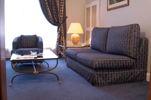 a living room with a couch and a chair at Grand Hotel Ukraine in Dnipro