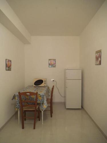 Zimmer mit einem Tisch und einem Kühlschrank in der Unterkunft Casa MoDerna 25SX in Castellammare del Golfo