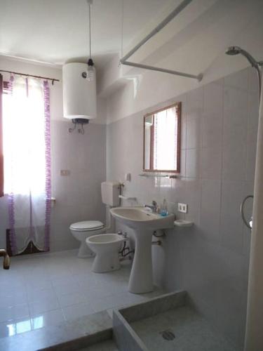 ein weißes Bad mit einem WC und einem Waschbecken in der Unterkunft Casa MoDerna 25SX in Castellammare del Golfo