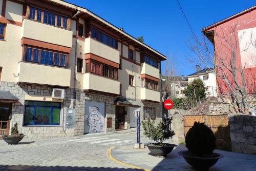 um edifício numa rua da cidade com um sinal de stop em Apartamento en Navacerrada em Navacerrada