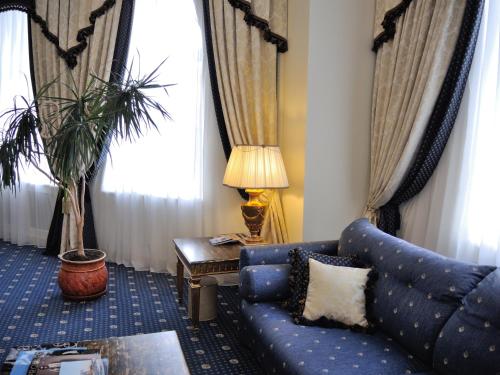 a living room with a blue couch and a table at Grand Hotel Ukraine in Dnipro