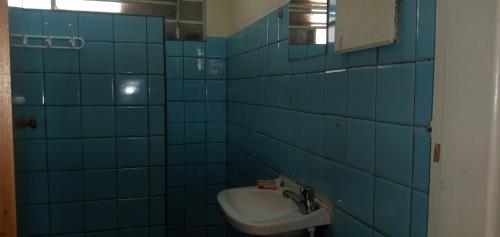 Casa recanto do mosteiro في ريبيراو بريتو: حمام من البلاط الأزرق مع حوض ومرآة