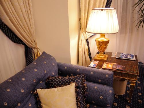 a living room with a blue couch and a lamp at Grand Hotel Ukraine in Dnipro
