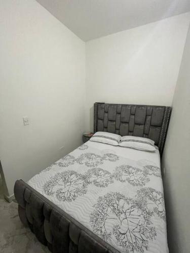 een slaapkamer met een bed met een zwart-witte deken bij Aparta-hotel laureles 201 in Medellín