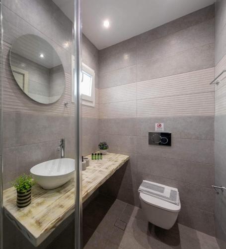 a bathroom with a sink and a toilet and a mirror at HELIAIA in Naxos Chora