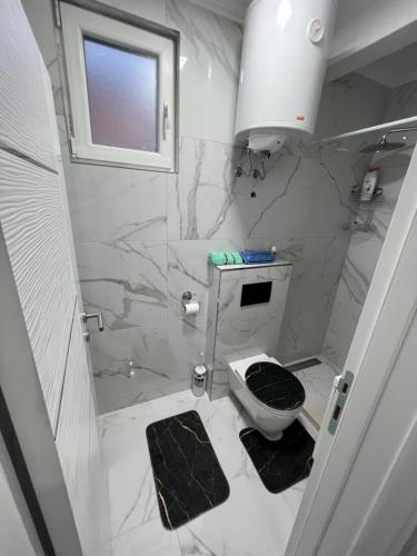 a white bathroom with a toilet and a sink at Apartman Bajo 1 in Foča